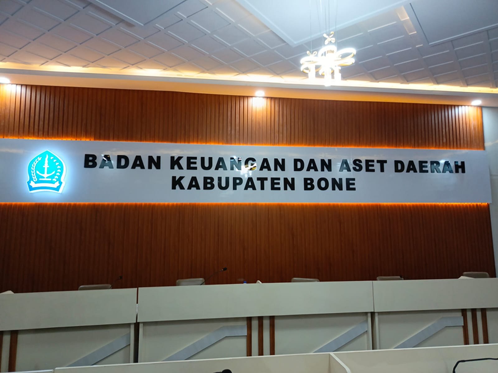 Interior ruang rapat BKAD Kabupaten Bone dengan wall panel kayu dan signage