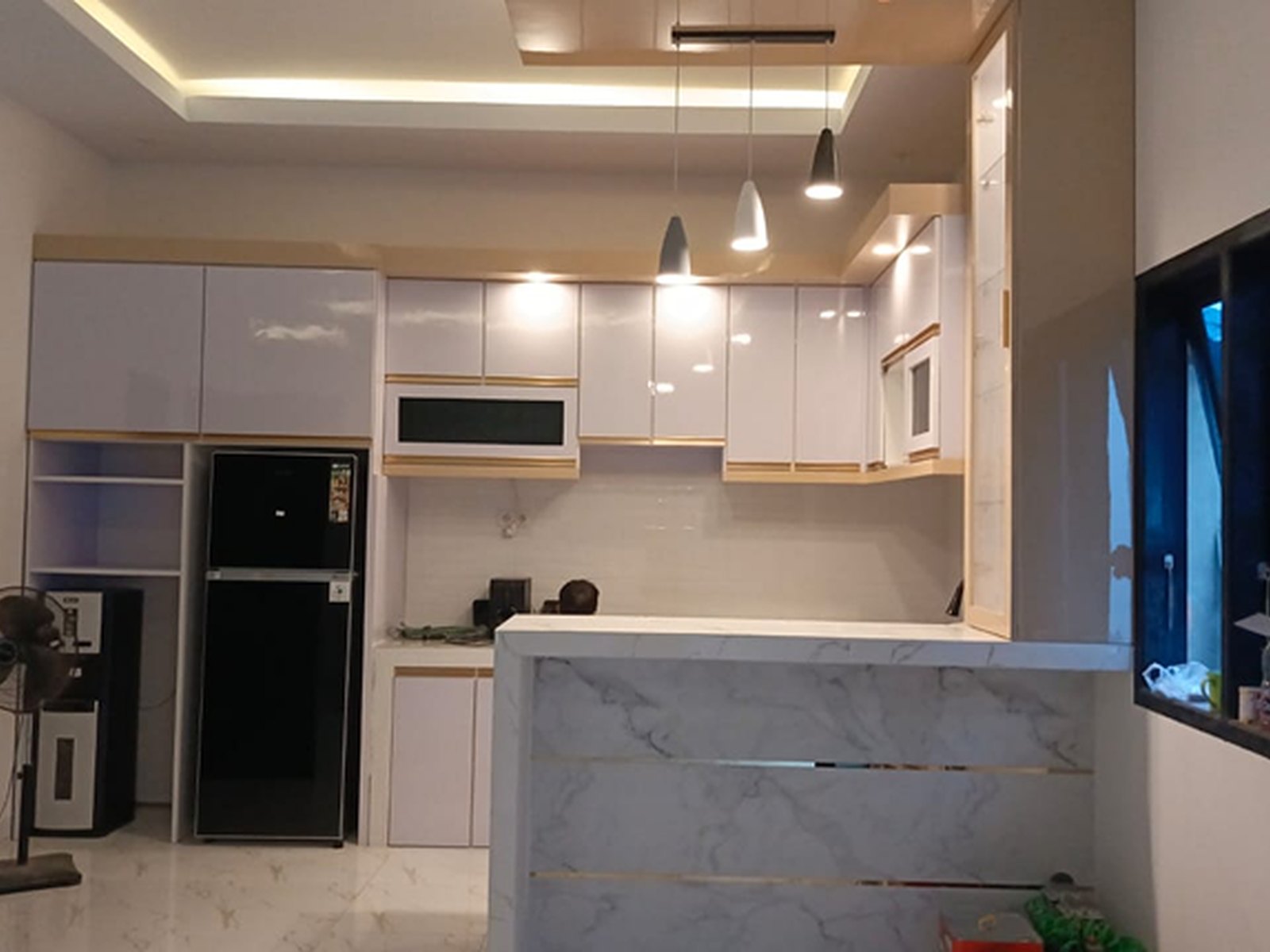 Kitchen set rumah hunian Jalan Majang dengan kabinet putih dan meja bar